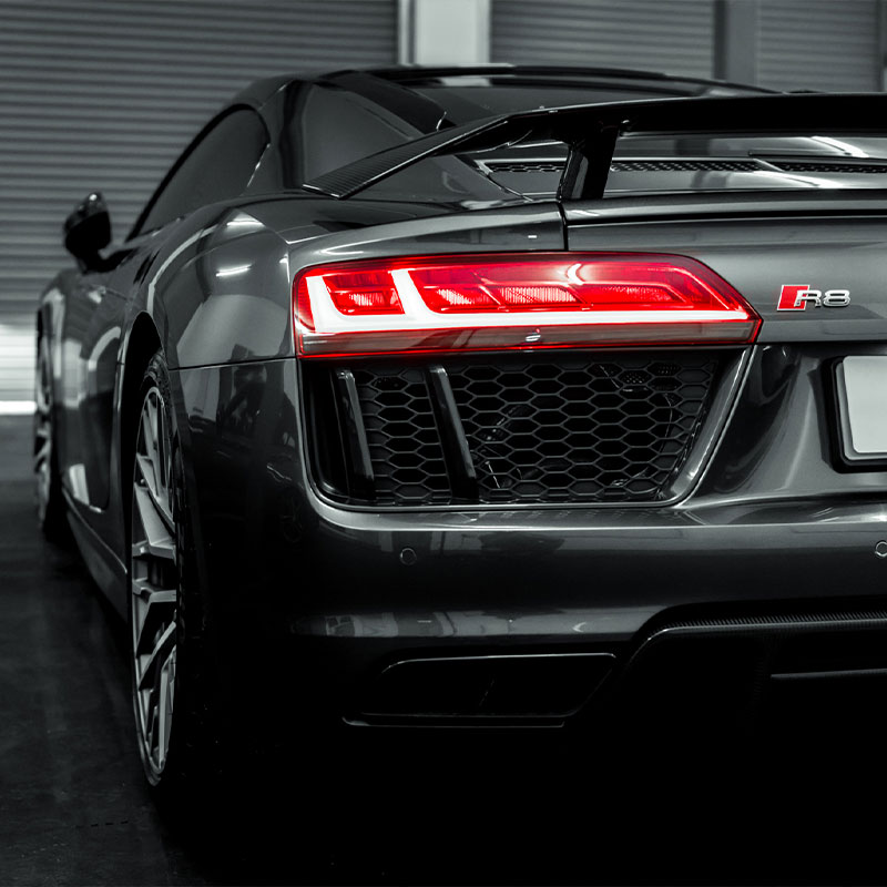 Audi R8 Plus with the rear sidelights on in a mono grey tone