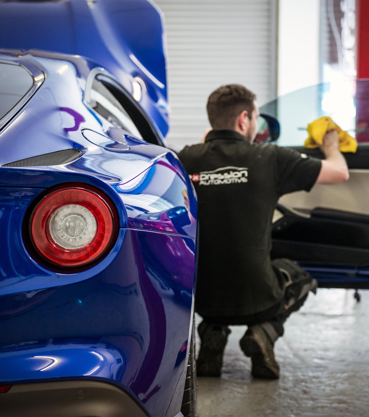 A blue Ferrari F12 having window tints installed